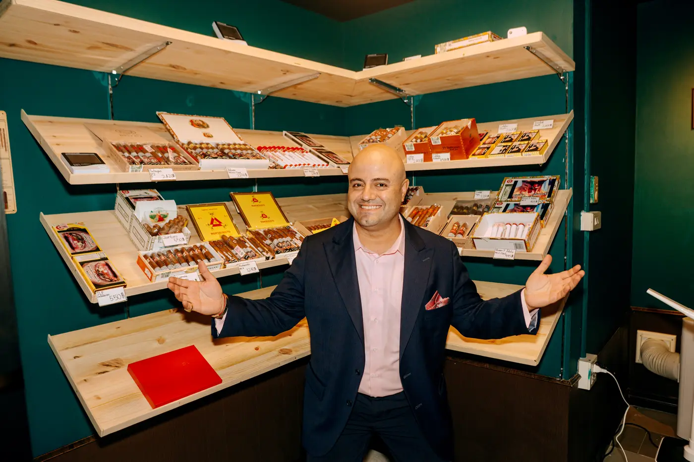 Founder at CNX Cigars humidor, arms wide, Nimman Chiang Mai